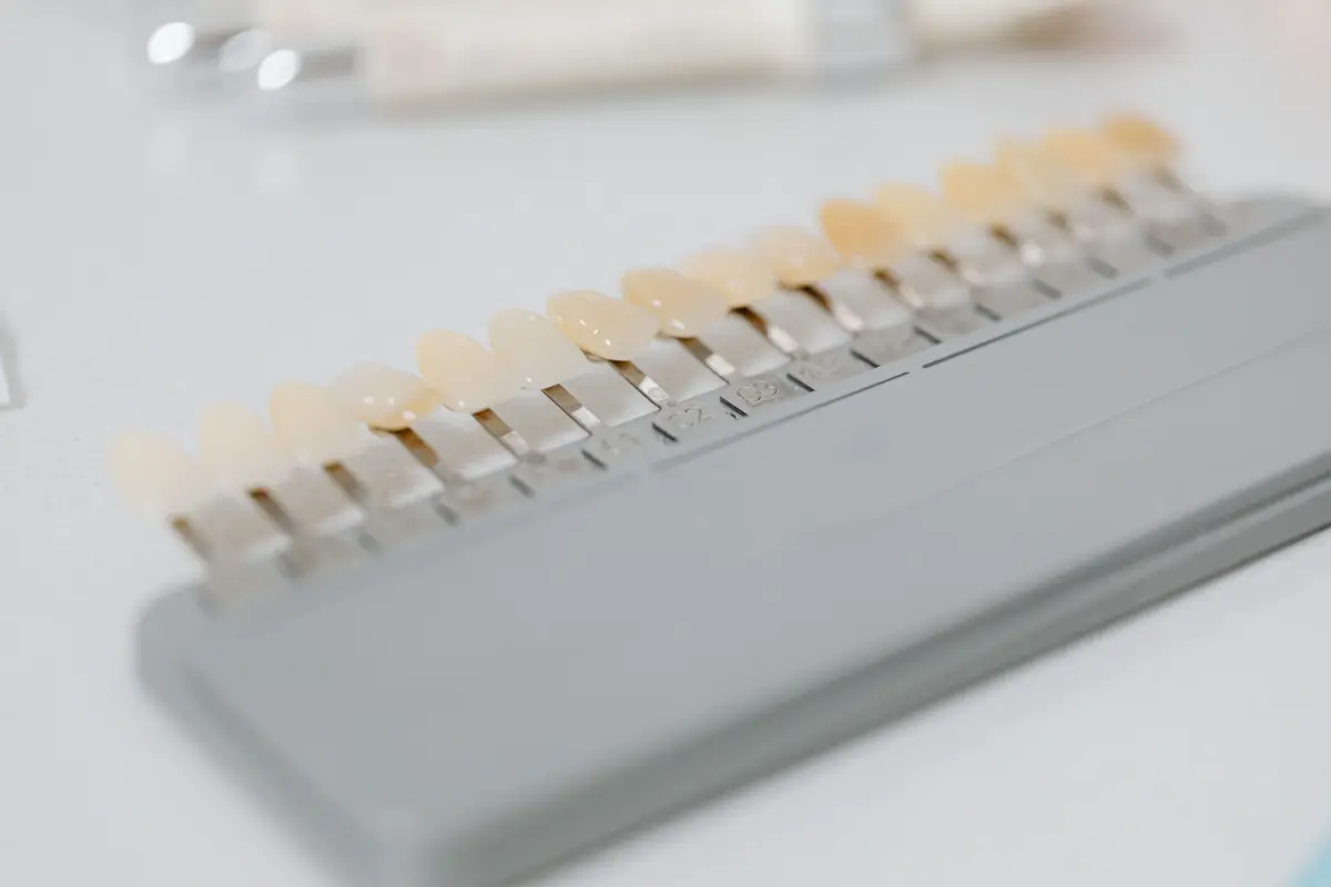 A dental shade guide laid out with tooth color samples